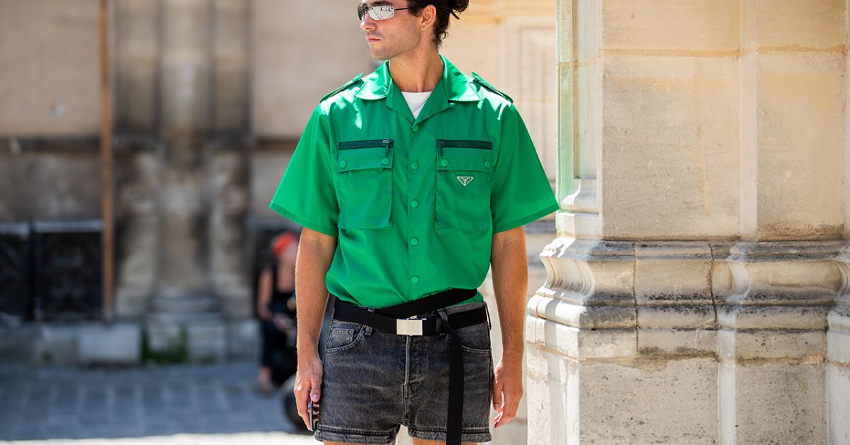  A man wearing a green shirt and shorts, showcasing a stylish summer outfit for casual occasions.